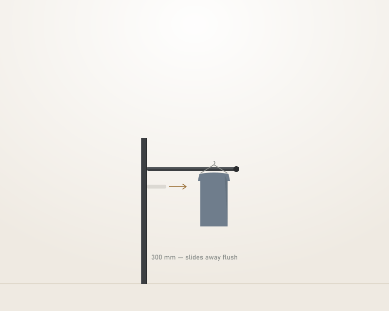 A slim aluminium valet rod extended from a wardrobe frame with a single shirt on a hanger, and a ghosted outline showing it slid away flush